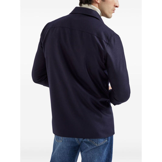 Man wearing Brunello Cucinelli Shirts Blue from the back, featuring long sleeves and buttoned cuffs, styled with jeans for a casual look.