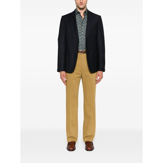 Man wearing Paul Smith Shirts MultiColour with teal blue floral print and classic collar, styled with a black blazer and beige trousers.