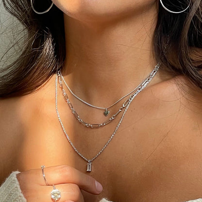 Woman wearing layered silver necklaces and hoop earrings showcasing 24KAE JEWELS JEWELRY Mod. 32422S design elegance.