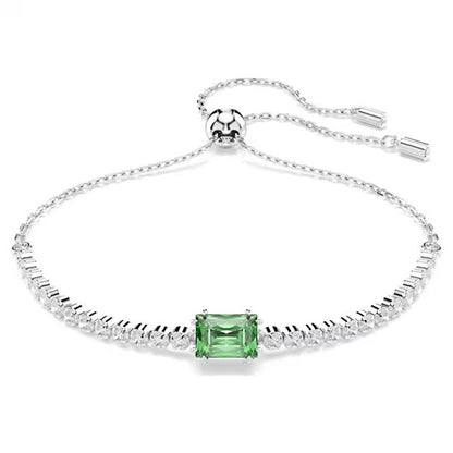 Elegant silver bracelet with central green gemstone, ideal for formal occasions.