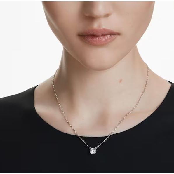 Woman wearing SWAROVSKI necklace with a square pendant on a delicate chain, showing elegance and style.