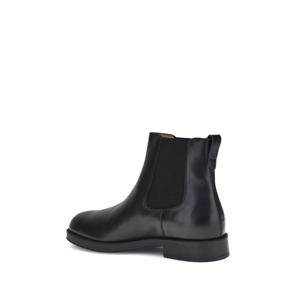 Side view of Tod's Black Calf Leather Bos Taurus Chelsea Boots showcasing round toe and elastic inserts for style and comfort.