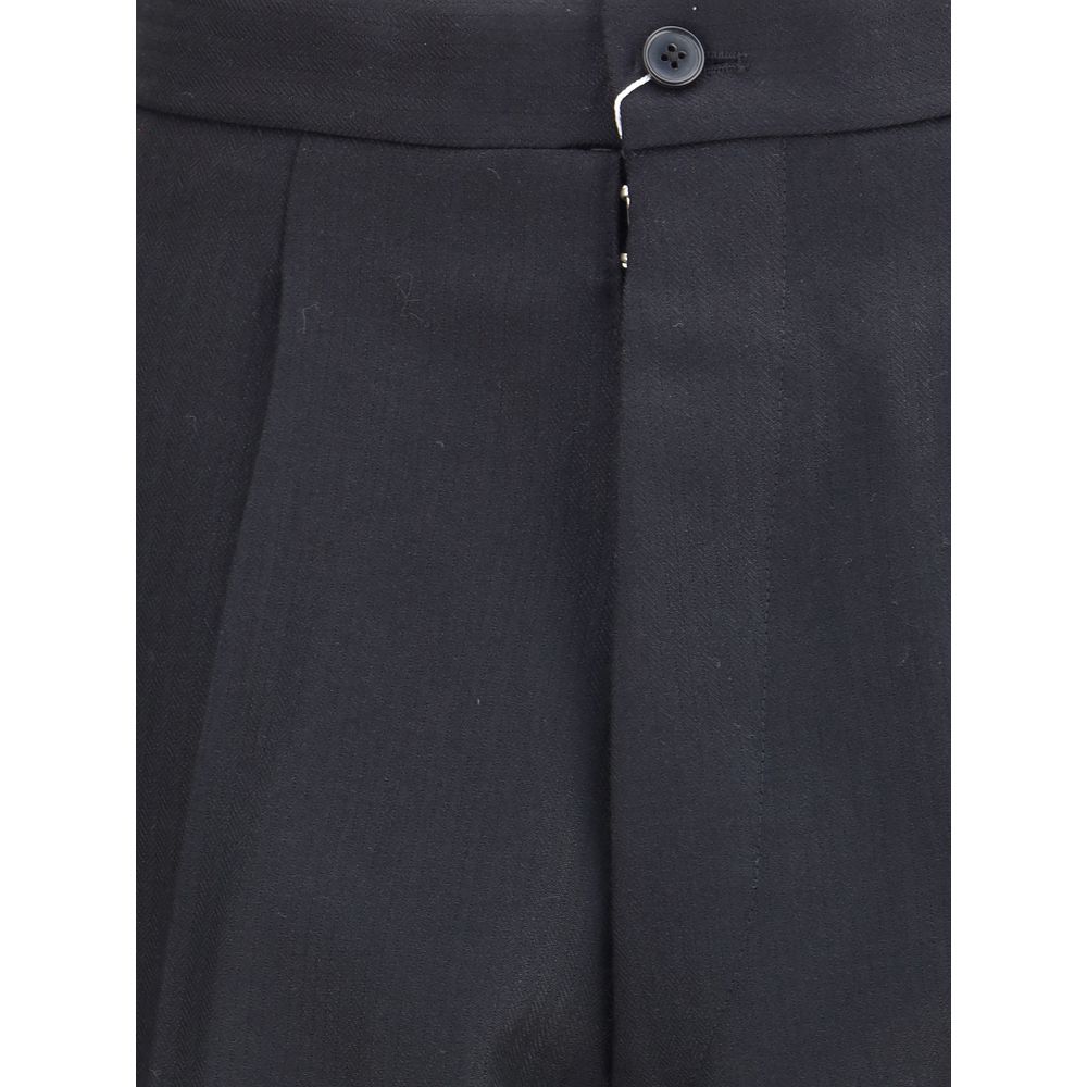 Close-up of Margiela Black Wool Dress Pants showing pleated front and logo hook-and-button closure.