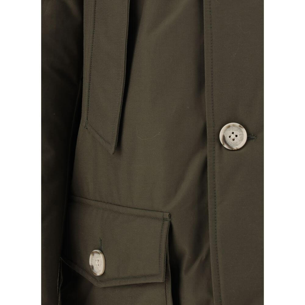Close-up of Woolrich Green Cotton Parka with buttons and side pocket, showcasing craftsmanship and design details for AW25.