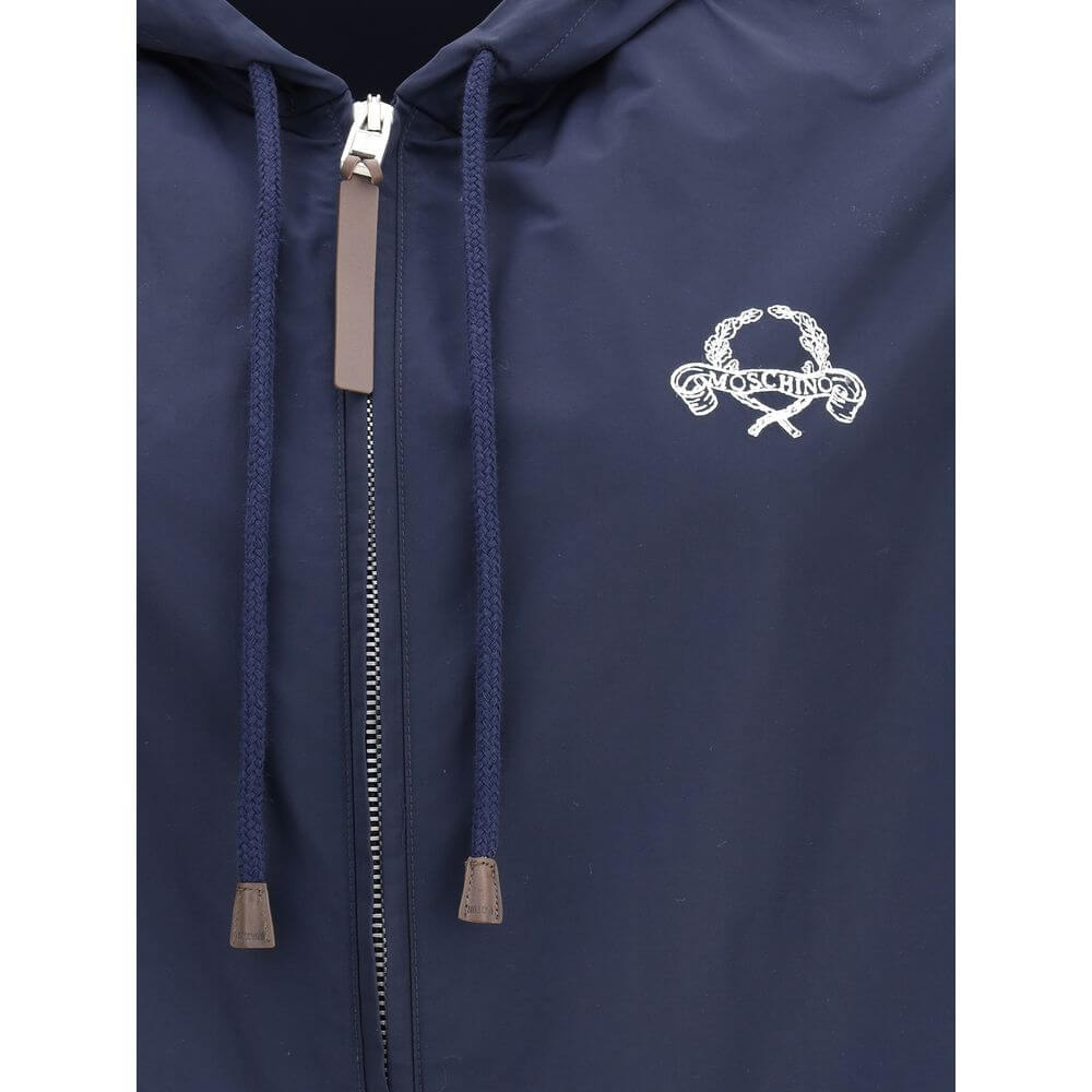 Close-up of Moschino Blue Polyester Shell Jacket with a hood, zipper closure, logo detail, elasticized hem and cuffs for waterproof protection.