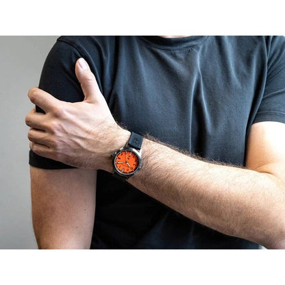 A man wearing a NAUTICA Mod. NAPCFS915 watch with orange dial and black band, showcasing its style and features.