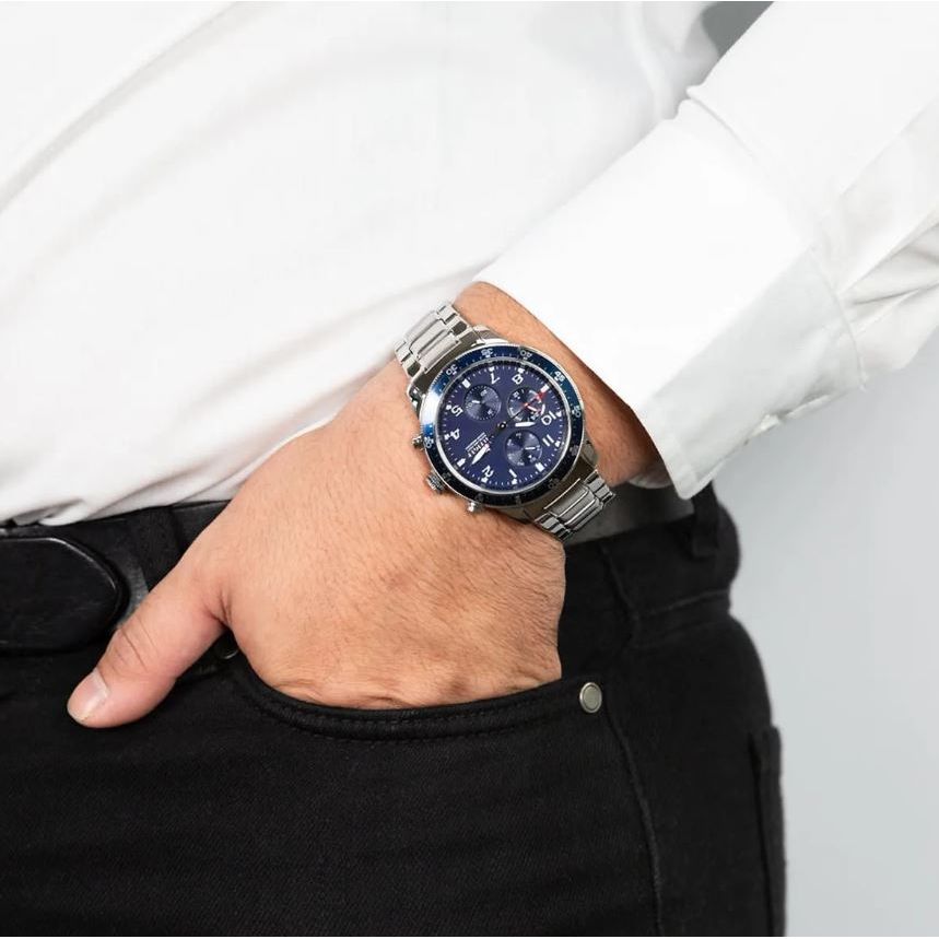 Gent wearing TOMMY HILFIGER Mod. 1791949 quartz analog watch, 44mm case, 5 ATM water resistance, on wrist, official box packaging included.