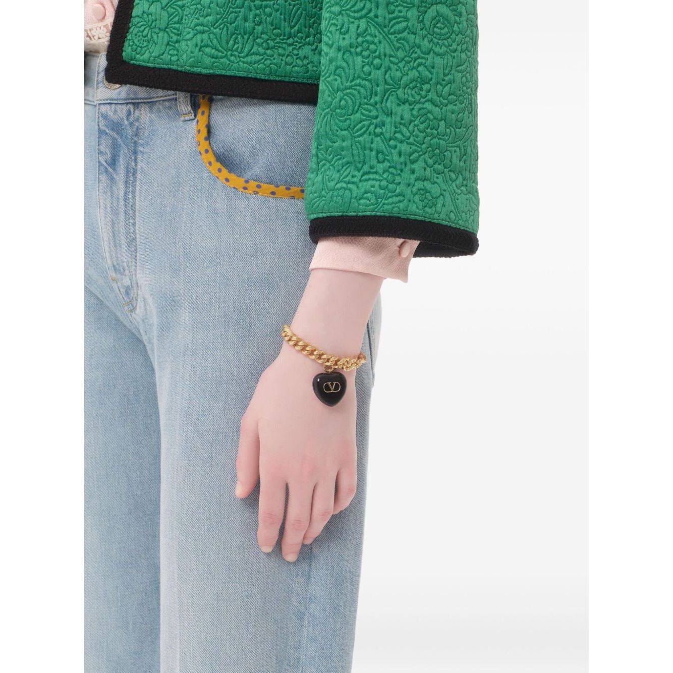 Person wearing Valentino Garavani Coeur Royal Bracelet with black heart charm and chunky chain.