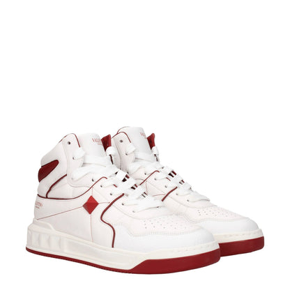 Valentino Garavani White Leather High Top Sneakers with red accents and studs, featuring front and side logos, lace-up closure, and rubber sole.