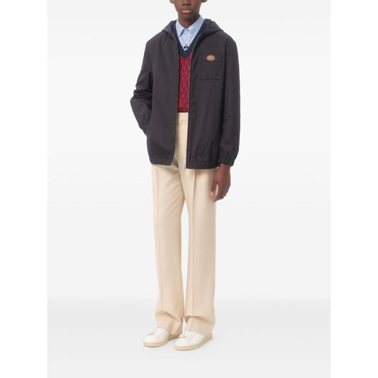 Man wearing Valentino Nylon Hooded Jacket with VLogo Patch in navy blue, featuring front zip, hood, and chest patch pocket.